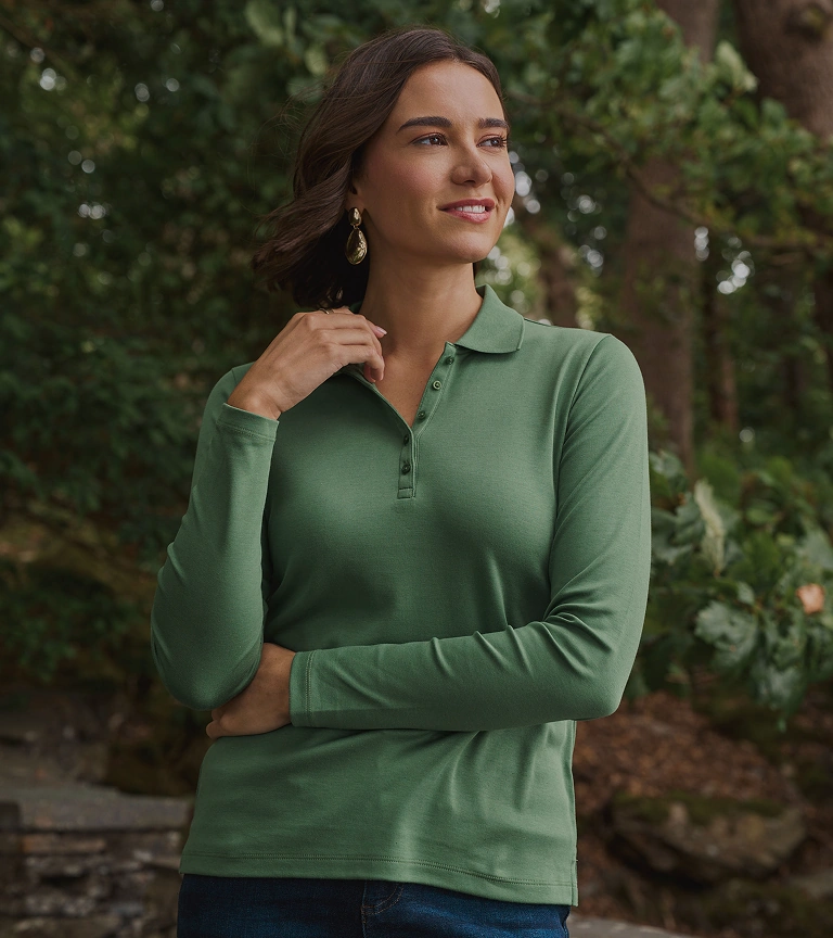 Woman wearing a green quarter-zip jumper and jeans outdoors
