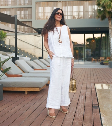 Woman wearing a white Lands’ End linen top and trousers