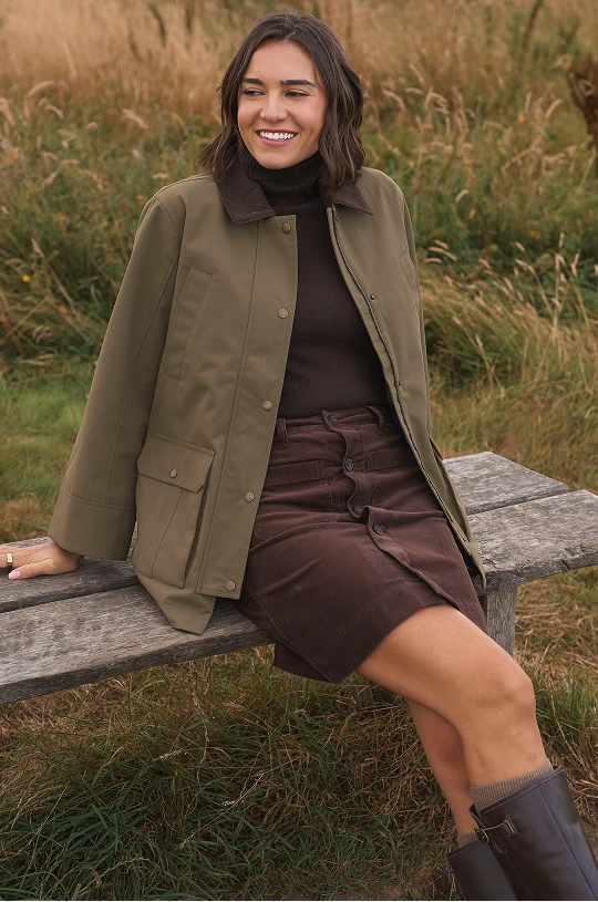Woman wearing a burgundy jumper and wide leg jeans outdoors