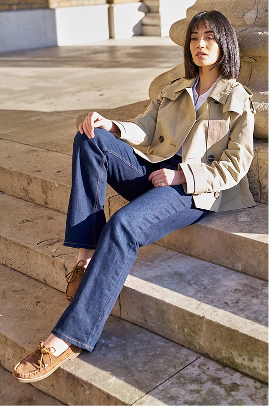 Woman wearing a jacket and Soft Denim Flared Jeans sitting on steps