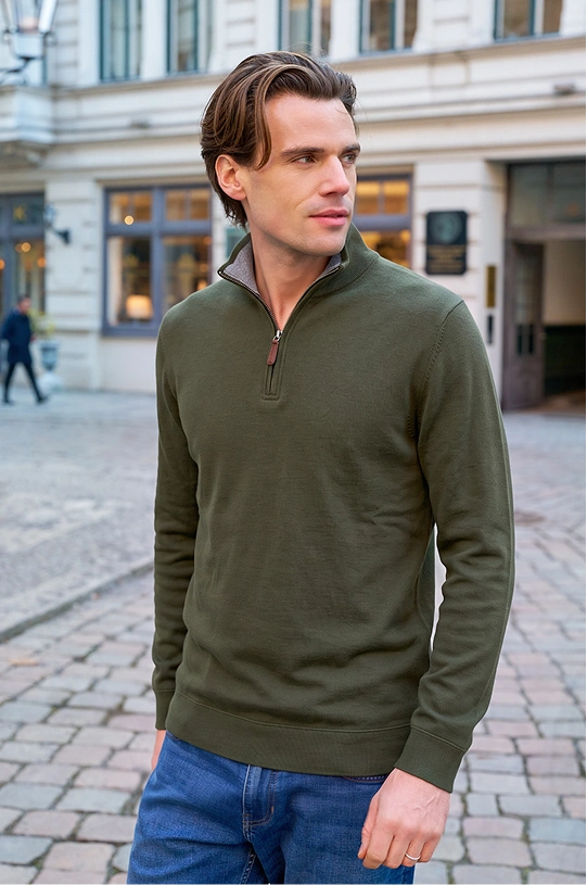 Man wearing a green Bedford Jumper and jeans outdoors