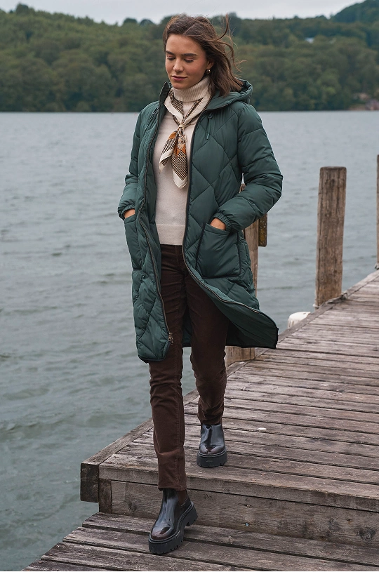 Woman wearing a lightweight raincoat, striped top and jeans