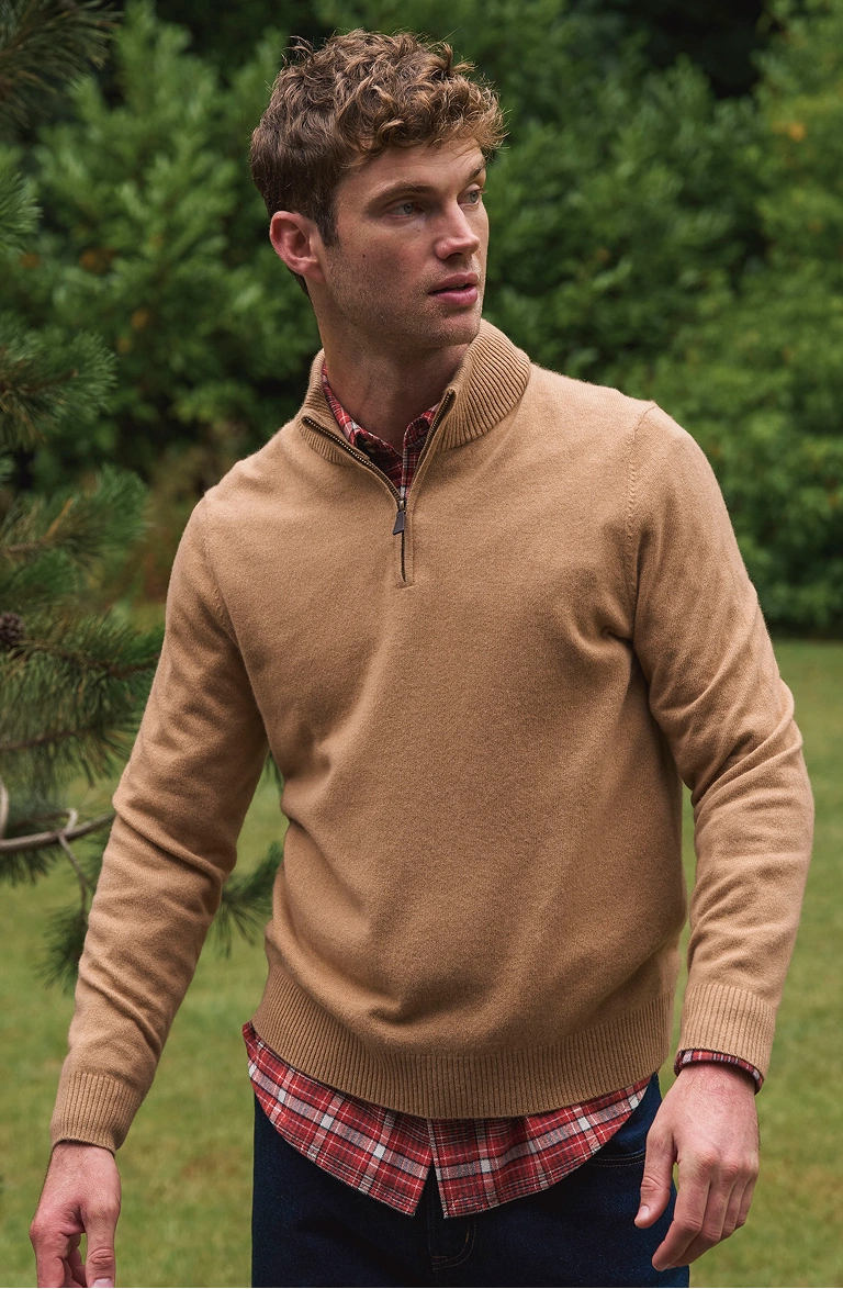 Man wearing a quarter-zip jumper and checked shirt outdoors