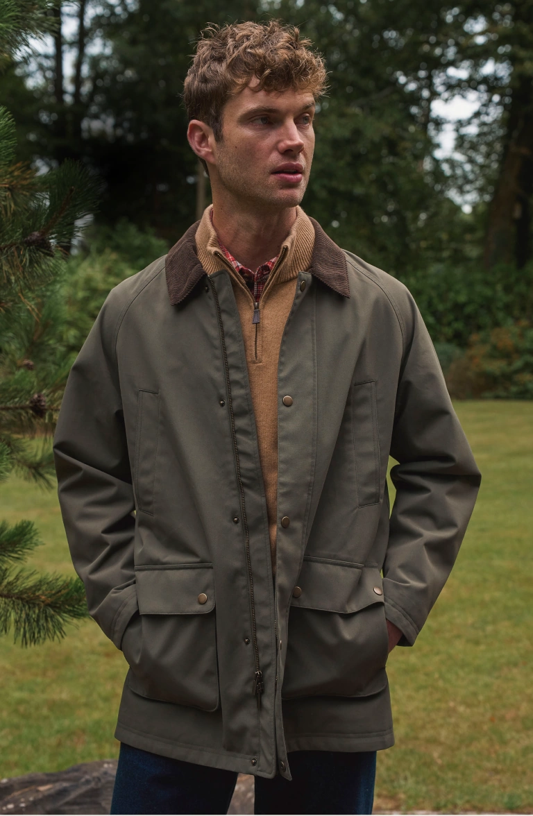 Man wearing a quarter-zip jumper and checked shirt outdoors